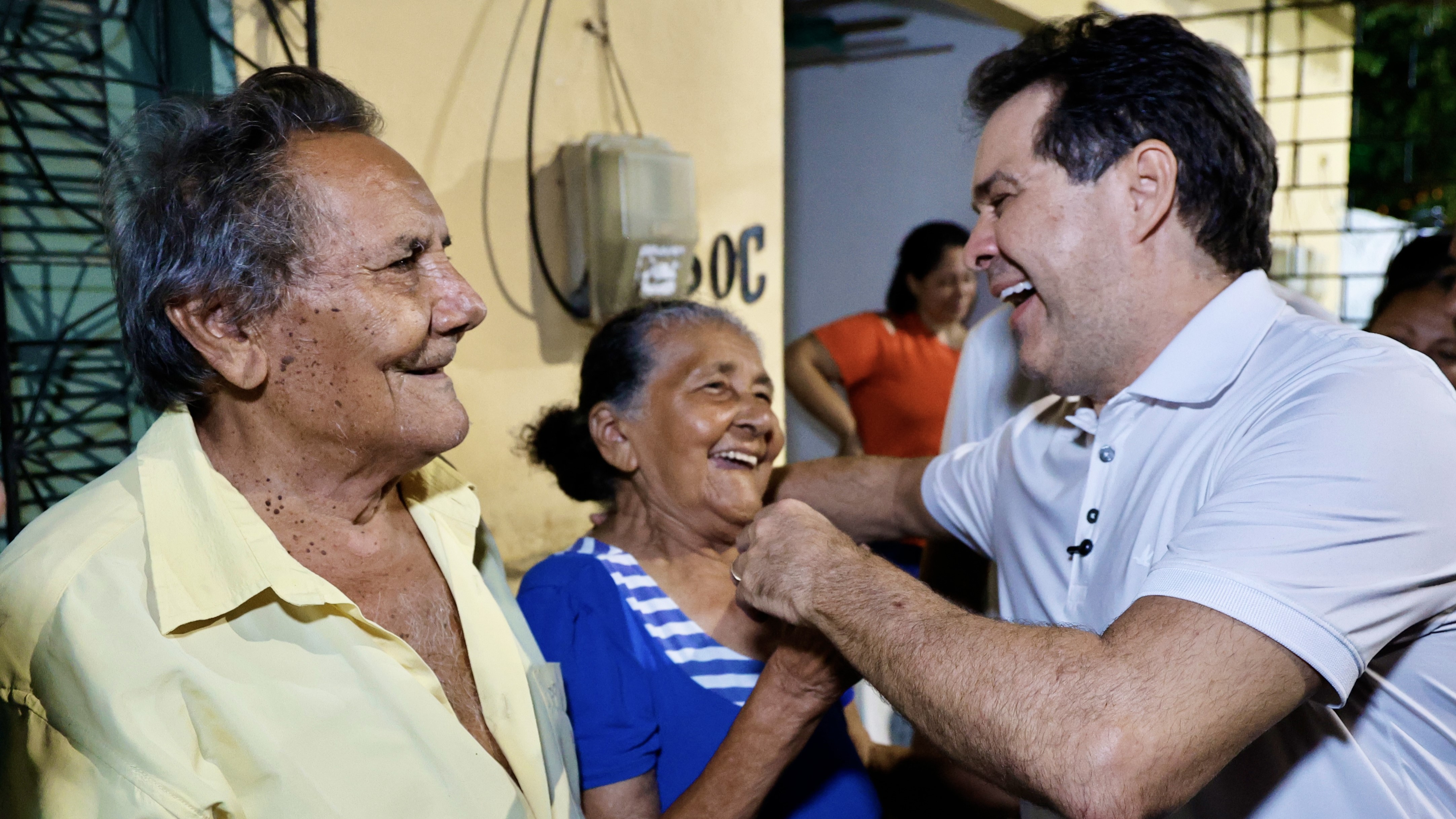 Evandro abraça uma senhora na porta da casa dela